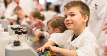 Kids sitting in a row learning in a science lab