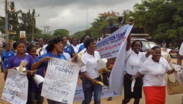 People gathered and marching in a protest with signs.