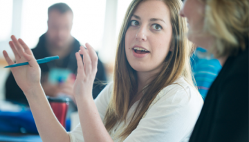 Student-gesturing-with-hands-to-another-student