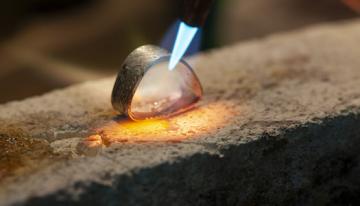 Metal ring being forged with blue flame