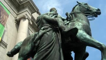 Picture of statue of a person on a horse outside the New York City Museum.