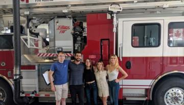 Students-standing-in-front-of-red-and-white-fire-truck