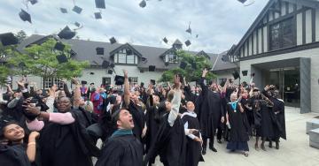 The spring 2023 graduates of the MAGL program at Royal Roads University throw up their hats in celebration