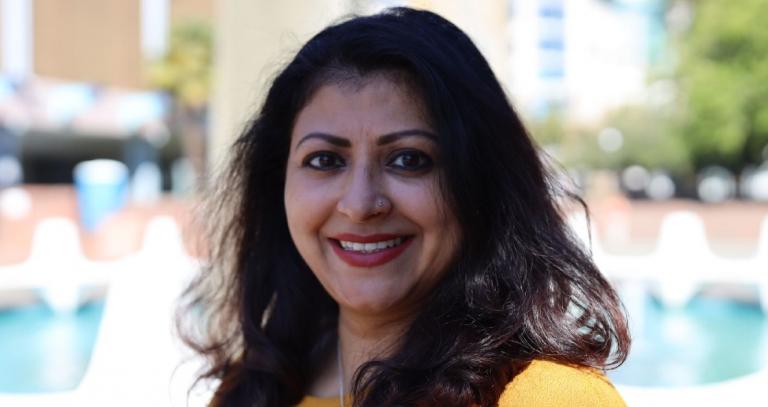 RRU graduate Mazumdar smiling for a photo outdoors