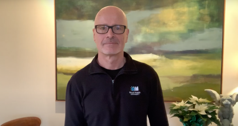 President Philip Steenkamp standing in front of a contemporary painting of a field.