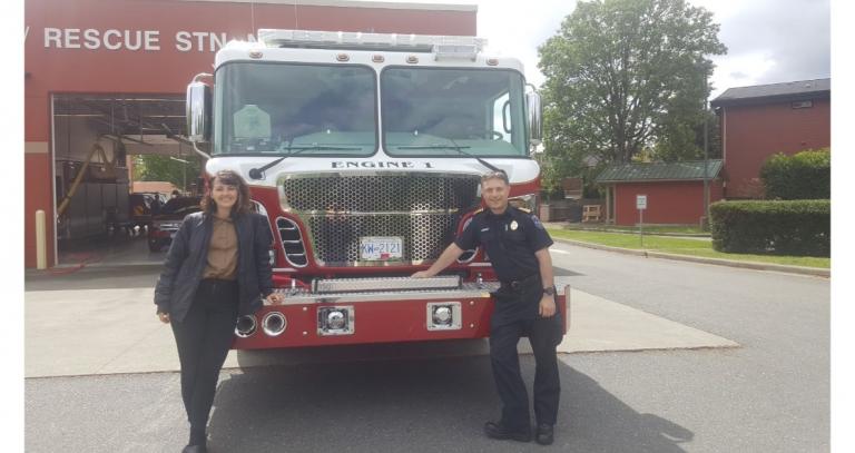 Student Jaya Bremer with a firefighter in front of a red fire truck