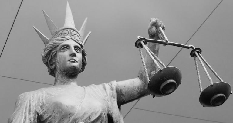 Scales of Justice statue in black and white.