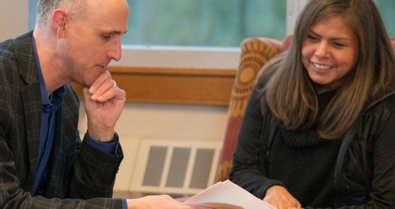 Two RRU leaders reviewing a document sitting around a table