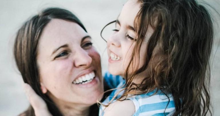 Mother and daughter smiling in each other arms