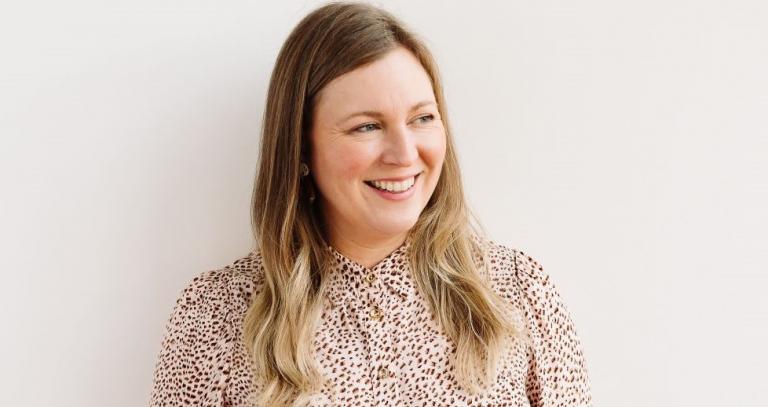 Smiling woman looks to the right of camera against a plain white background