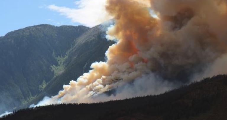 Fire and smoke seen on a mountain side.