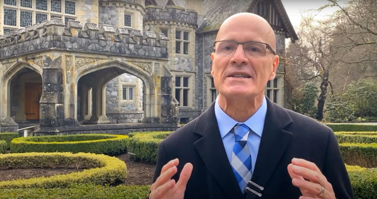 President Steenkamp outside Hatley Castle looking delighted to invite students back to campus for Convocation.