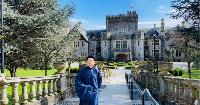 Will Nguyễn walking up the steps in front of Hatley Castle on a clear day