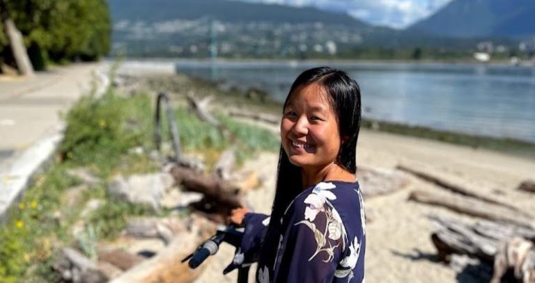 Annie Luke demonstrates a scooter on a path running adjacent to the beach