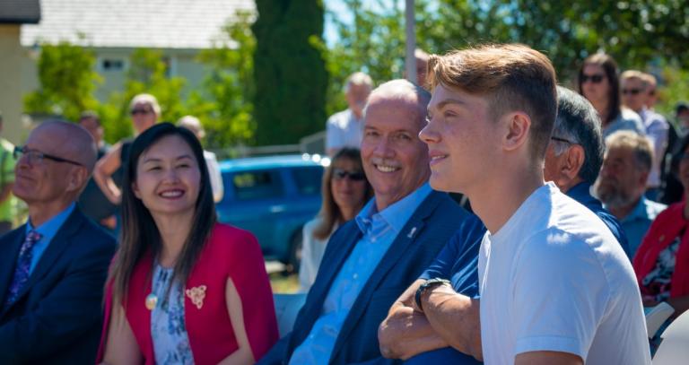 Belmont student Connor Hogan looks in to the distance and smiles as RRU President Steenkamp, Minster Kang and Premier Horgan look on.
