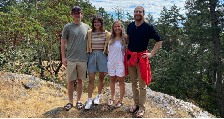 Four students stand a top a lookout point in a Gary Oak ecosystem.