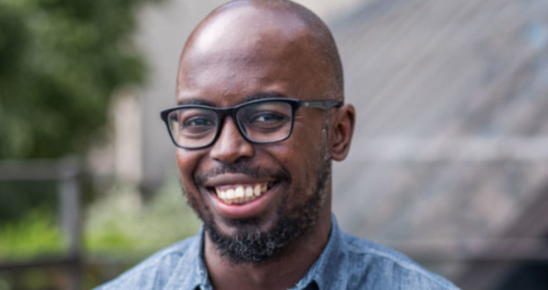 Lawrence Jarikre smiles while posing for a headshot.