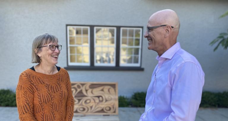 Jean Slick and President Philip Steenkamp chat outside the Sherman Jen Building.