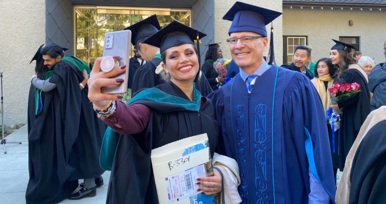 President Streenkamp poses for a picture with a graduate.