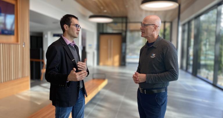 Prof. George Veletsianos has an animated talk with President Philip Steenkamp.