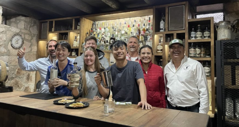 A group of student pose for a photo behind a bar in Mexico.