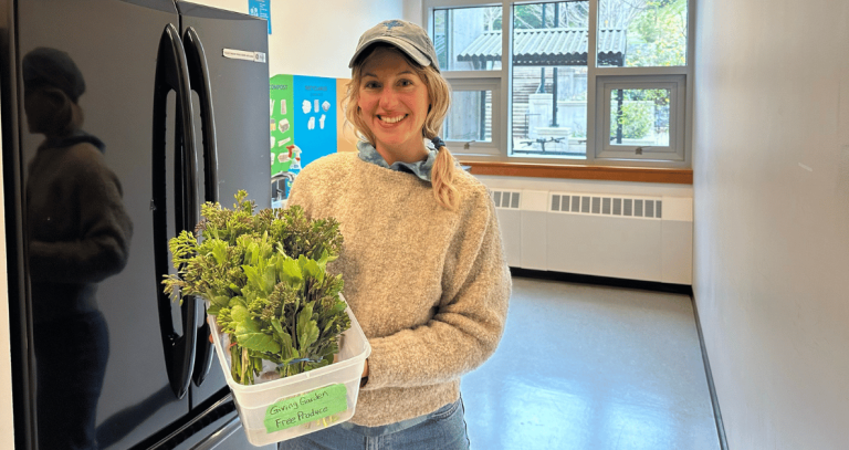 Women standing in front of a fridge holding a bucket of freshly picked rapini.