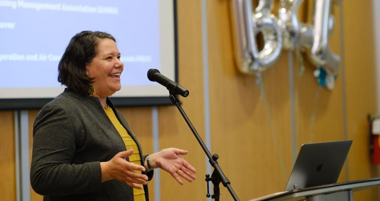 woman with short dark hair speaking into a microphone