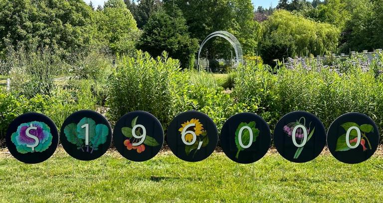 Decorative signs sit atop green lawn at Royal Roads University spelling out $196,000 for a gift from TD bank