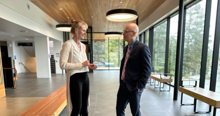 Prof. Jennifer Walinga and President Philip Steenkamp have a chat in the Dogwood Auditorium in the glassy reception area. 