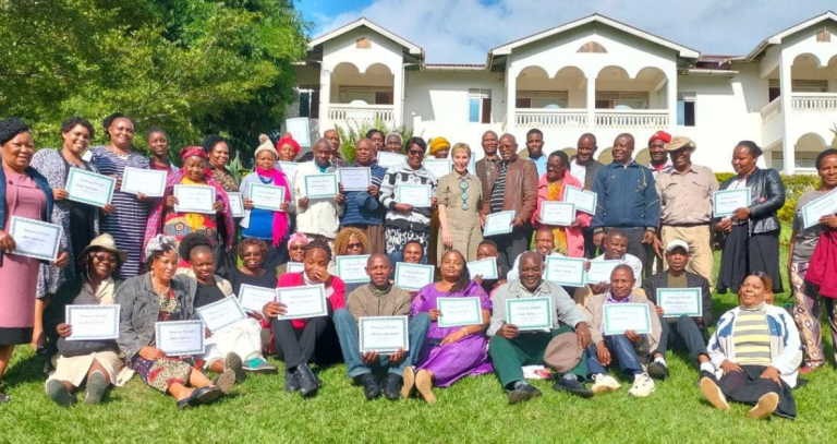 Workshop participants pose with their certificates of completion as homestay providers.