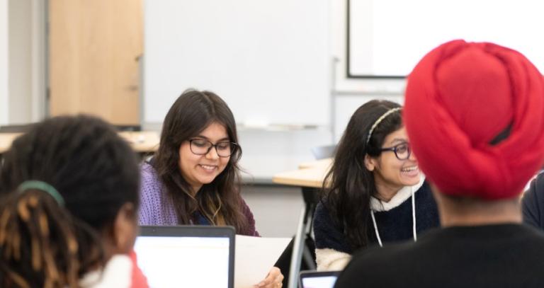 Four students sitting around a table. 