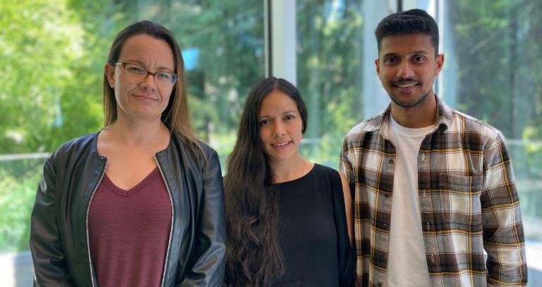 Alejandra Chacon Gallardo, Katherine Matos and Jofri Issac stand in the RRU library.