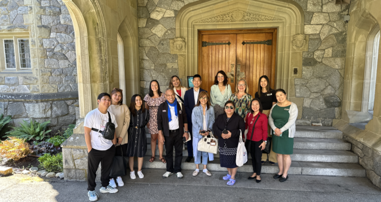 Group of Phillipine delegates and RRU staff standing on a set of stairs in front of Hatley Castle's door.