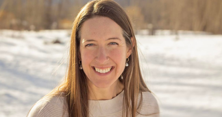 A woman smiles while posing for a head shot.