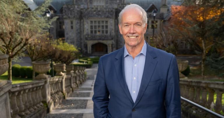 John Horgan standing outside Hatley Castle at Royal Roads University.