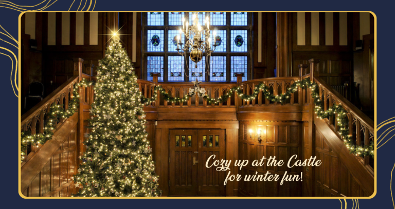The entrance to Hatley Castle aglow with a tree, candles and chandelier.
