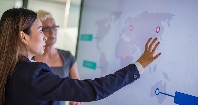 Students studying map of world projected on screen