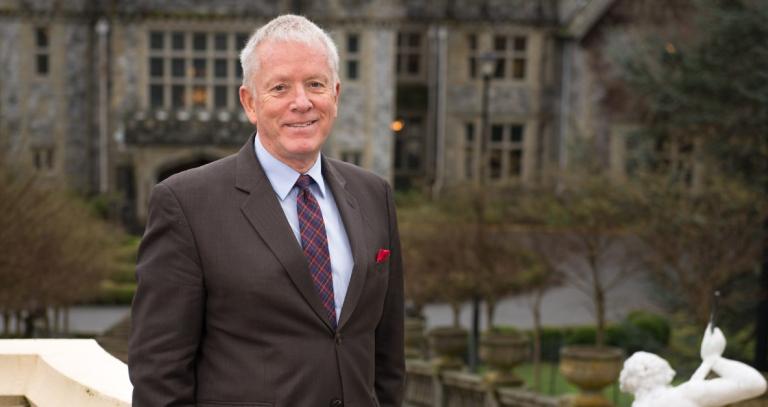 Allan Cahoon smiling at camera with Hatley Castle behind him.