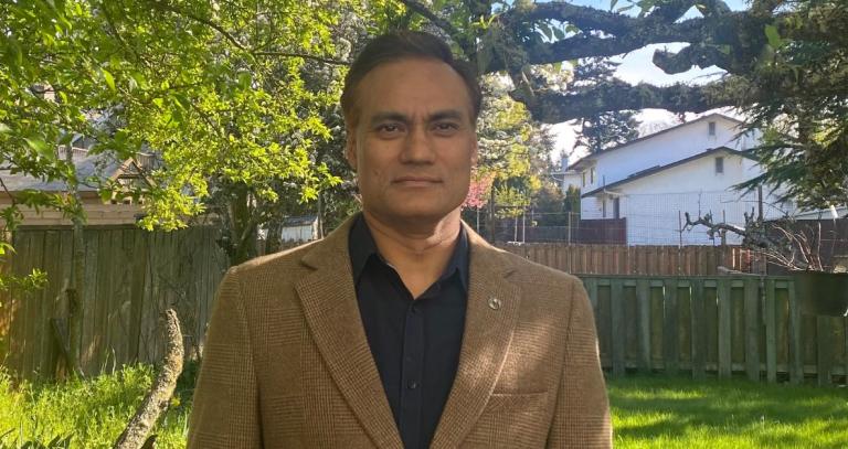 Rudra Shrestha standing in front of a natural environment