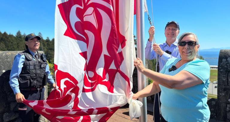 Shauneen, Philip and Stanley raise the Indigenous Flag
