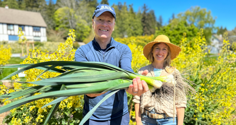 President Steenkamp and Solara Goldwynn, show off some fresh leeks pulled from the Giving Garden.