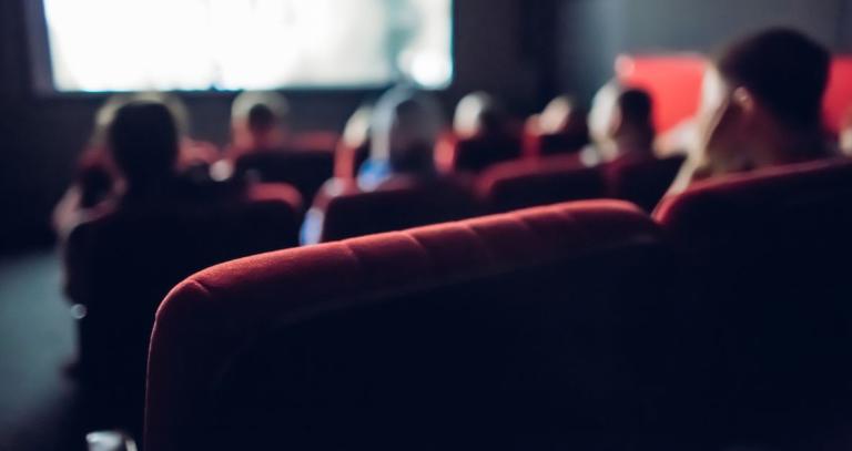 A movie theatre audience is seen from behind