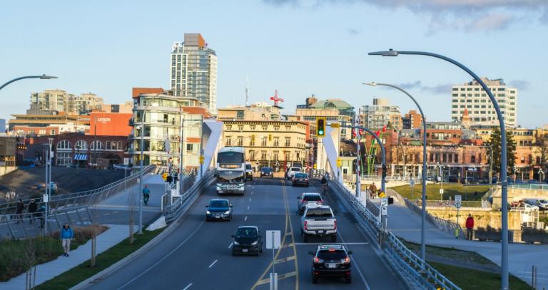 View of Johnson St. bridge with traffic and downtown Victoria buildings