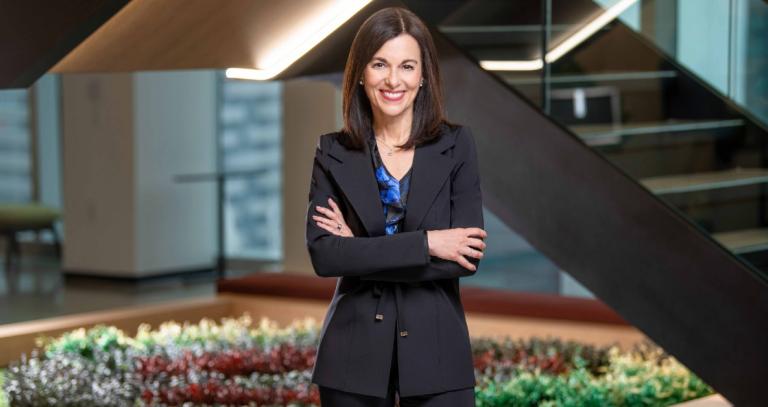 Veni Iozzo smiling and standing with her arms crossed.