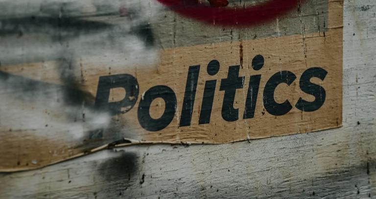 Concrete wall with the word politics written on it.
