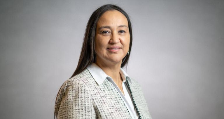 Christine Webster smiling in front of a grey backdrop