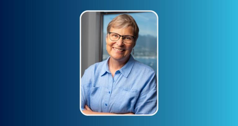 Lori Wanamaker smiling in front of a neutral background
