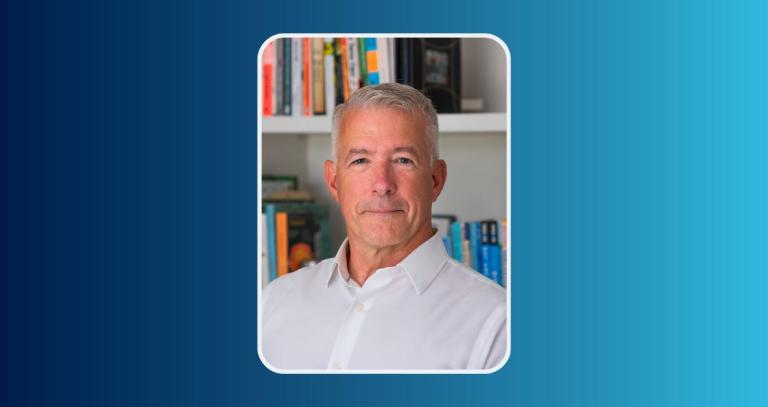 Curtis Clarke smiling in front of a book shelf