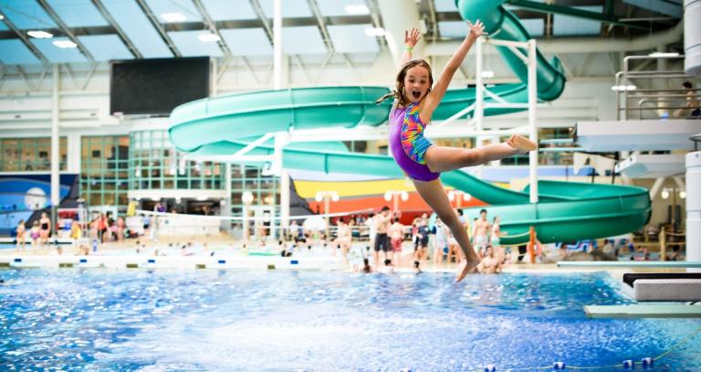 Young girl jumping into swimming pool. Photo credit: Saanich Parks & Recreation