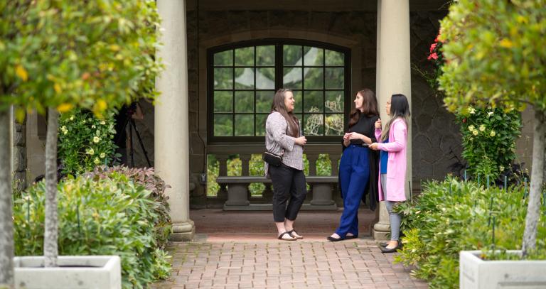 Three students chatting in garden.
